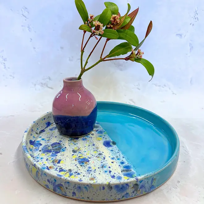 Shoreline Tray, a colourful tray placed on a stone surface accompanied by flowers. 
