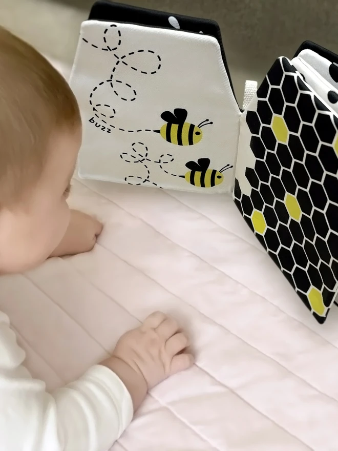 Baby during tummy time looking at My Quiet Book, High-contrast Soft Book