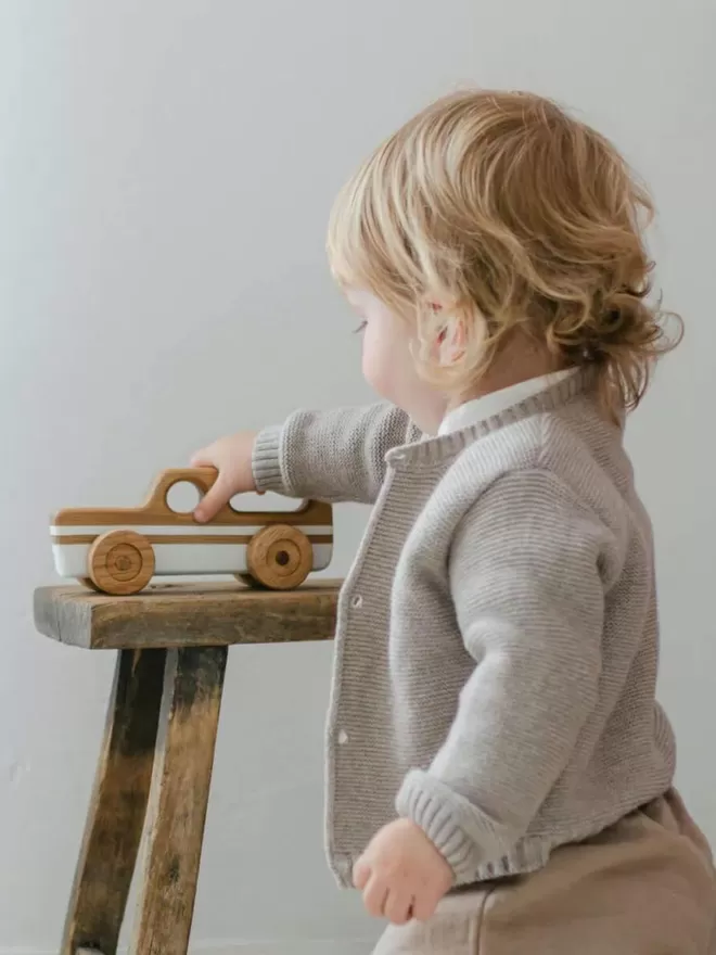 Wooden Toy Car Station Wagon in White with a little baby playing with the wooden toy