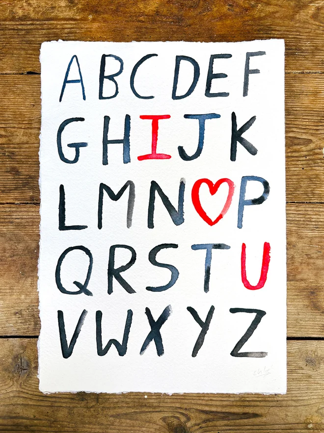 Handwritten alphabet 'I ❤️ U' artwork in watercolour on handmade paper with deckled edge