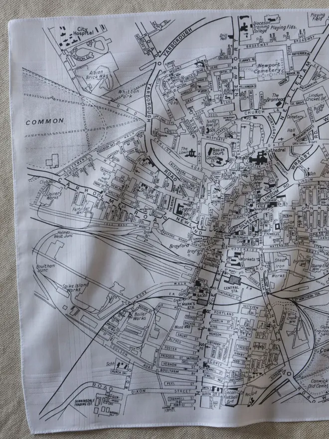 Mr.PS Lincoln Map Handkerchief screenprinted in grey, laid on a linen tablecloth