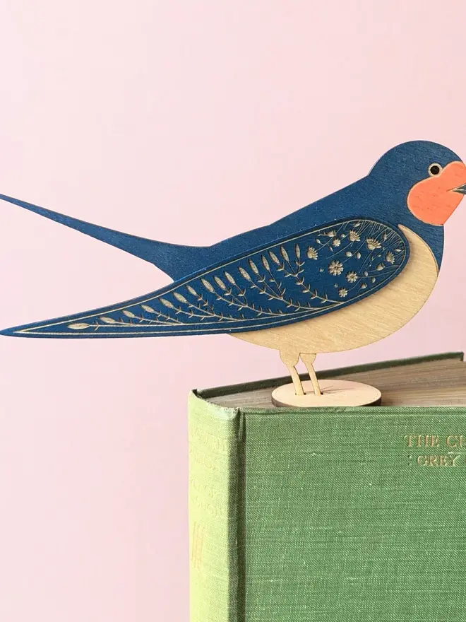 Standing Wooden Barn Swallow, blue wooden bird decoration standing on book. 