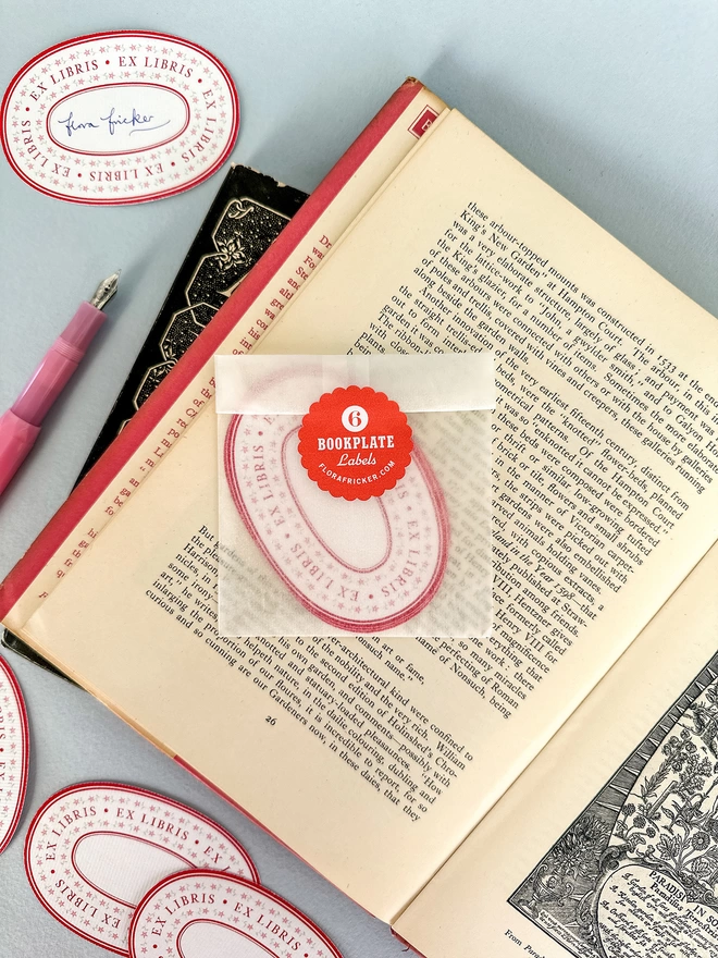 Bookplate labels packaged in glassine sleeve with red scallop sticker. Designed by Flora Fricker, graphic designer. Photographed in vintage book.