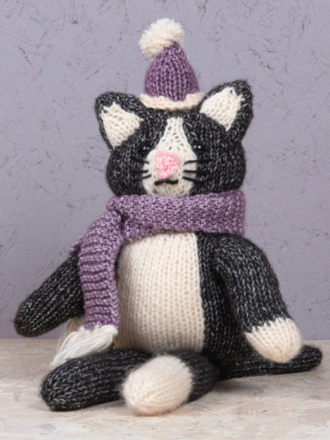 Cat in Knitwear Knitting Kit. A black cat with purple knitwear.