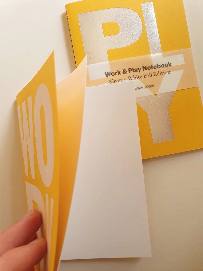 Yellow notebook with the words work and play on the cover