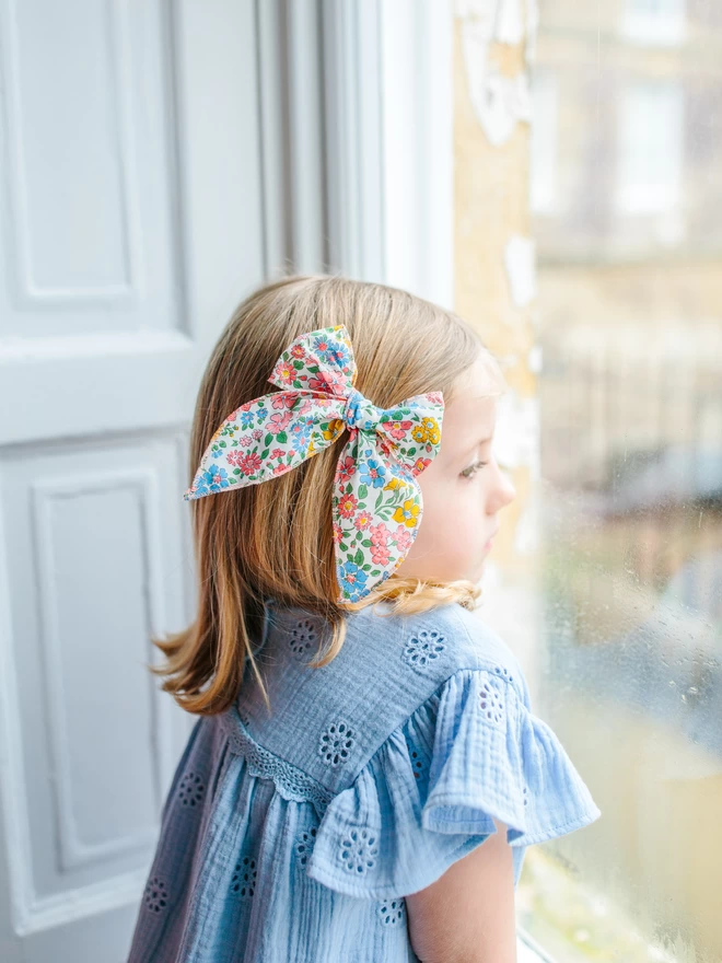 Liberty hair bow on girl looking out of window