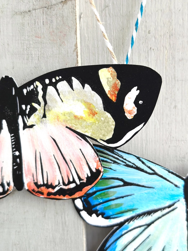 3 Hand Painted Butterflies. Set Of Linocut Wall Hangings. Close up of peach and yellow butterfly over a teal butterfly 