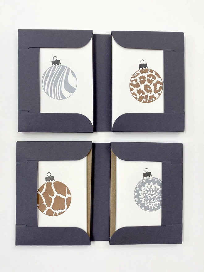 Open gift boxes showing all four animal print baubles 