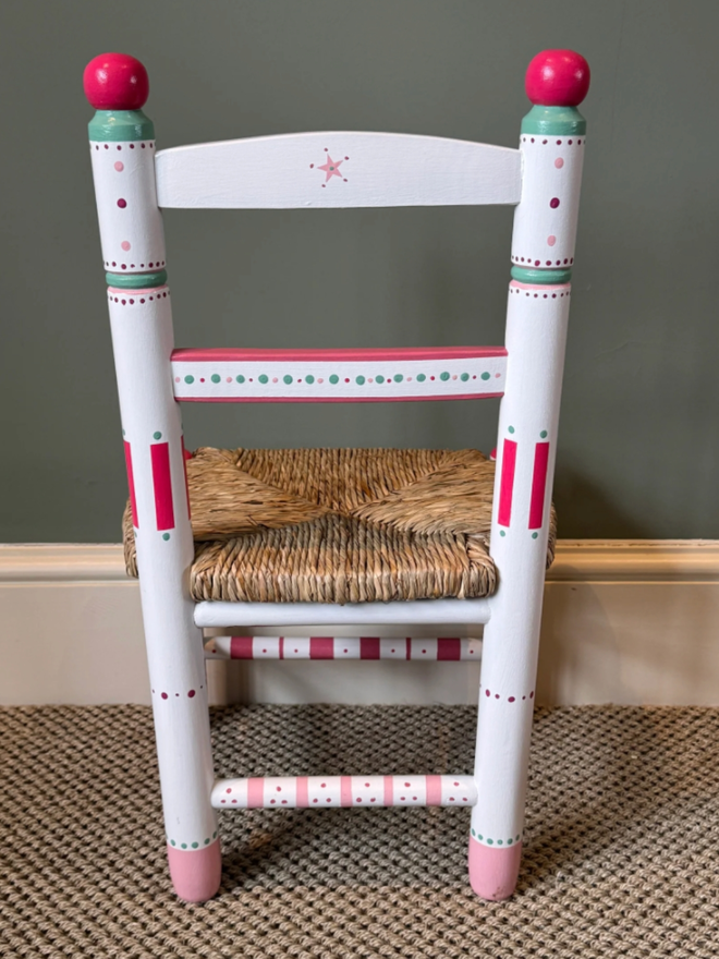 Marina Personalised Hand Painted Chair. A white chair with intricate red and green patterns.