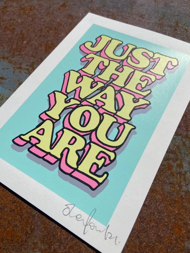 "Just The Way You Are” Mini A5 Hand Pulled Screen Print In pastel blue with the words just the way you are in hand drawn lettering printed on top with black outline and pink and yellow fill