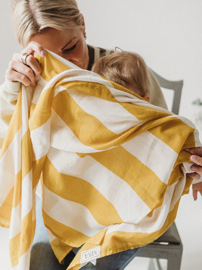 Yellow Stripes Muslin. A muslin with white and yellow stripes on a baby.