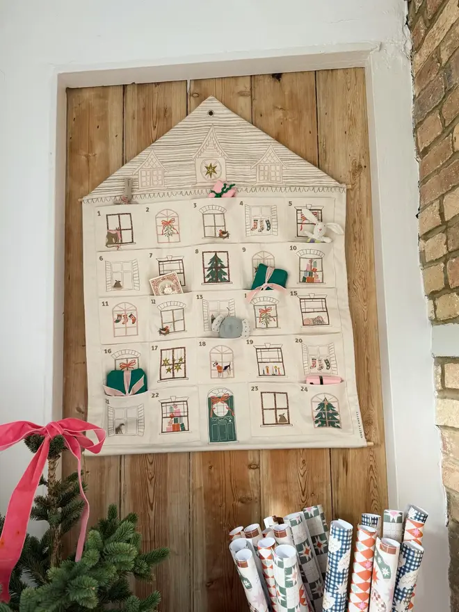Fabric Christmas House Advent Calendar, hanging on a door. 