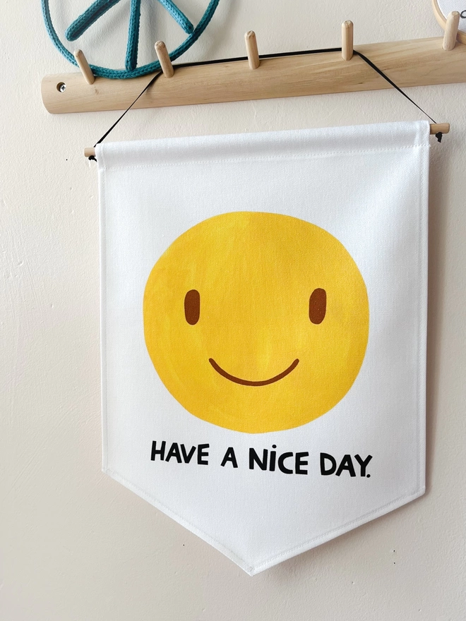 Smiley have a nice day banner hanging from a peg rail