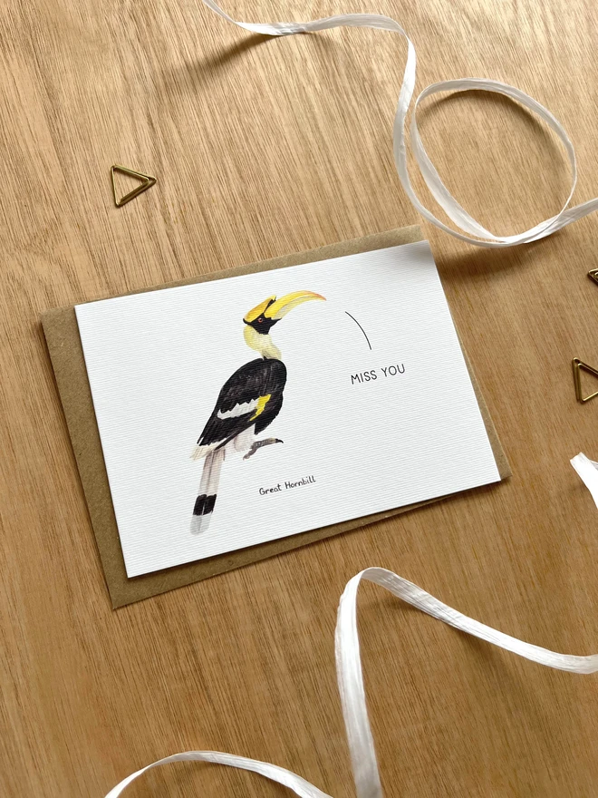 a greetings card featuring an illustration of a hornbill with the text “miss you”