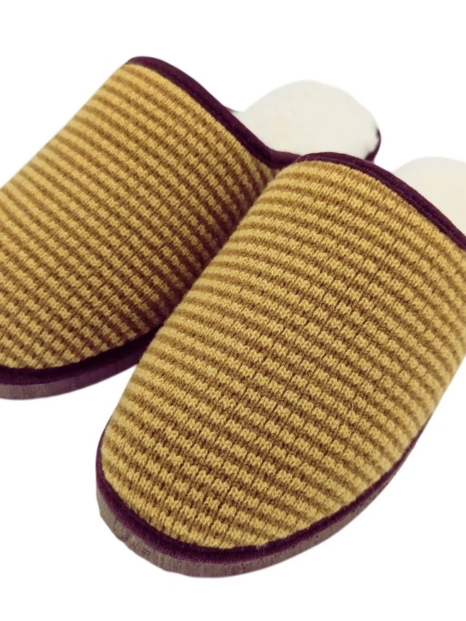 Lambswool & Sheepskin Slippers, a pair of colourful lambswool and sheepskin slippers sitting on a plain white surface. 