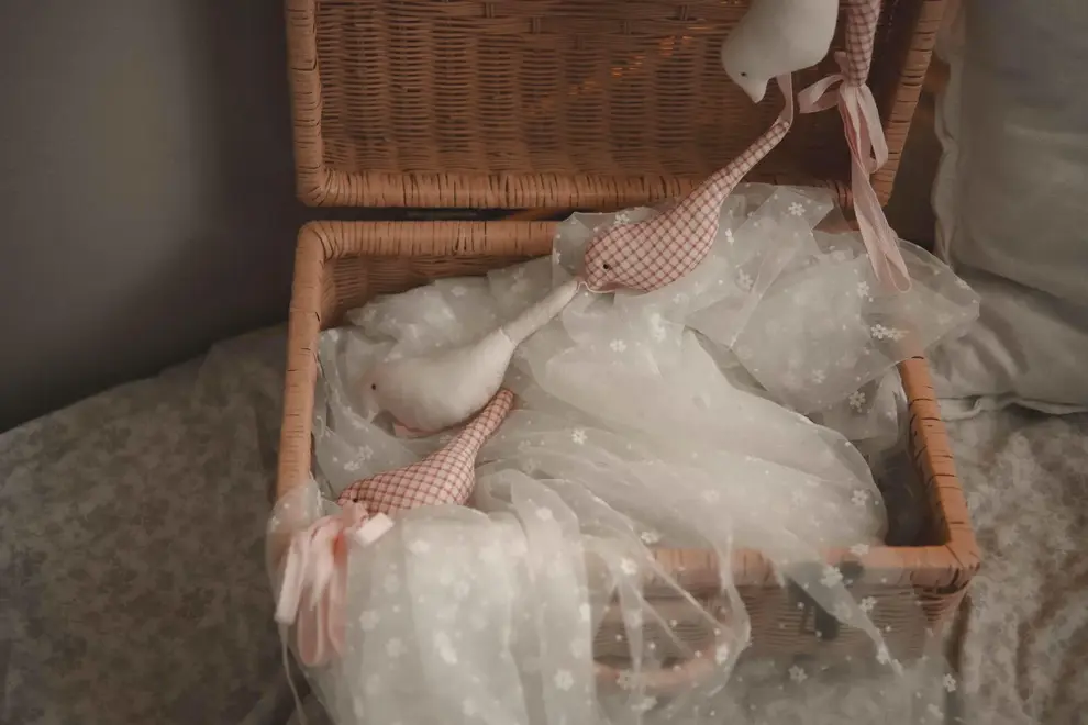 Cotton Bird Garland Decoration, a red and white cotton bird garland sitting on a wooden hamper. 