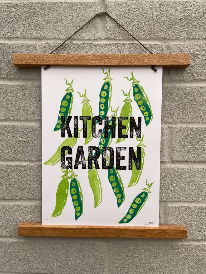 white paper printed with light and dark green pea pod illustrations, and black text reading "kitchen garden"