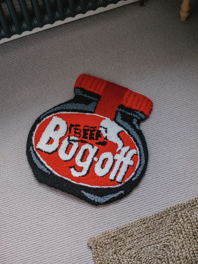 'Bog Off' Handmade Tufted Rug/Wall Hanging seen on a carpet.