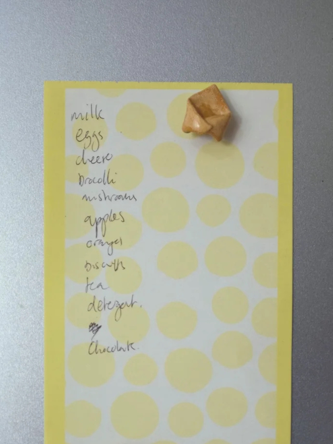 ceramic pasta magnet. a ceramic tortellini magnet on a fridge door.