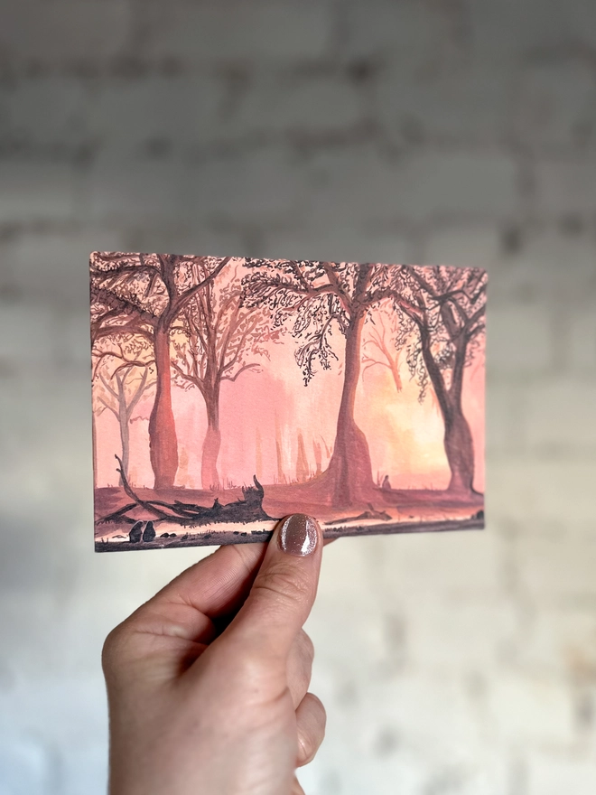 a greetings card featuring an illustration of a landscape of a sunset coming through trees with a few silhouettes of baboons enjoying it too
