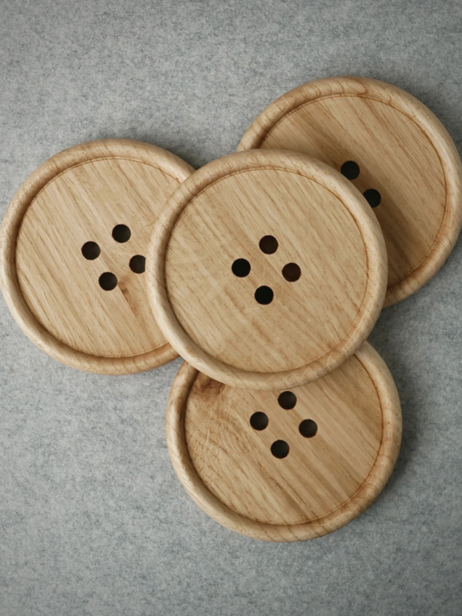 Wooden Button Drink Coaster. A bird’s eye view of four tan coasters.