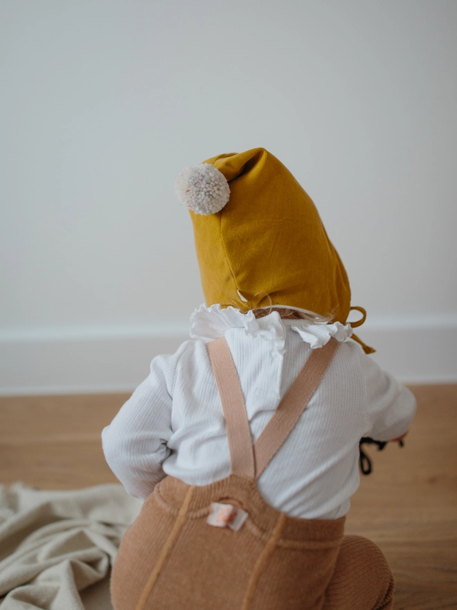 baby wearing her mustard pixie hat for winter 