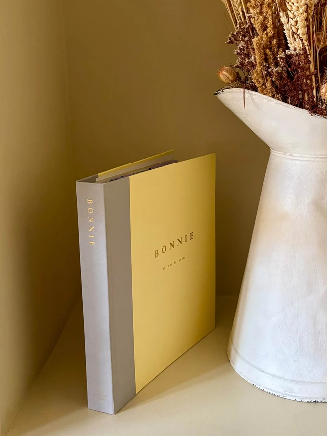 a personalised keepsake folder in grey and yellow. personalised with a child's name