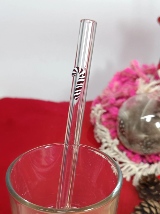 close up of a candy cane straw inside a glass