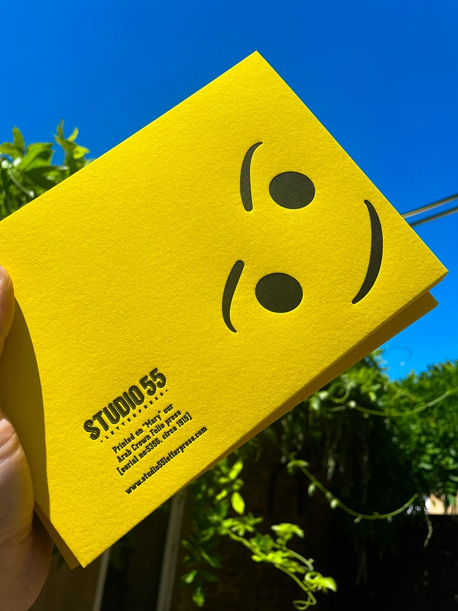 Bold yellow letterpress card featuring a playful upside-down smiley face design, printed by hand  byStudio 55 Letterpress on thick GFSmith Colorplan Factory Yellow premium card – available on Holly & Co