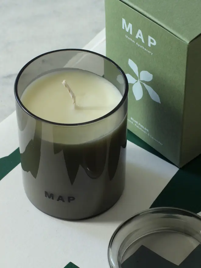 blue fields lavender and sandalwood candle. candle photographed next to plastic free packaging box.