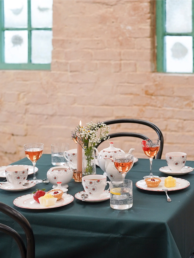 Floral Twist crystal bud vase holding colourful wildflower arrangements placed on a dark green tablecloth.