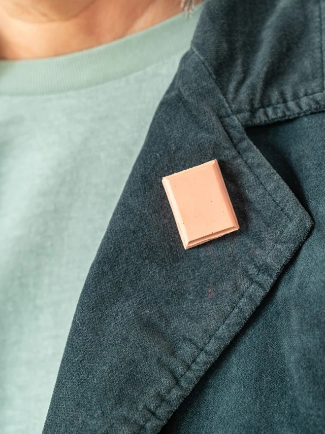 chocolate pin badges. a ruby pink chocolate badge on a coat lapel.