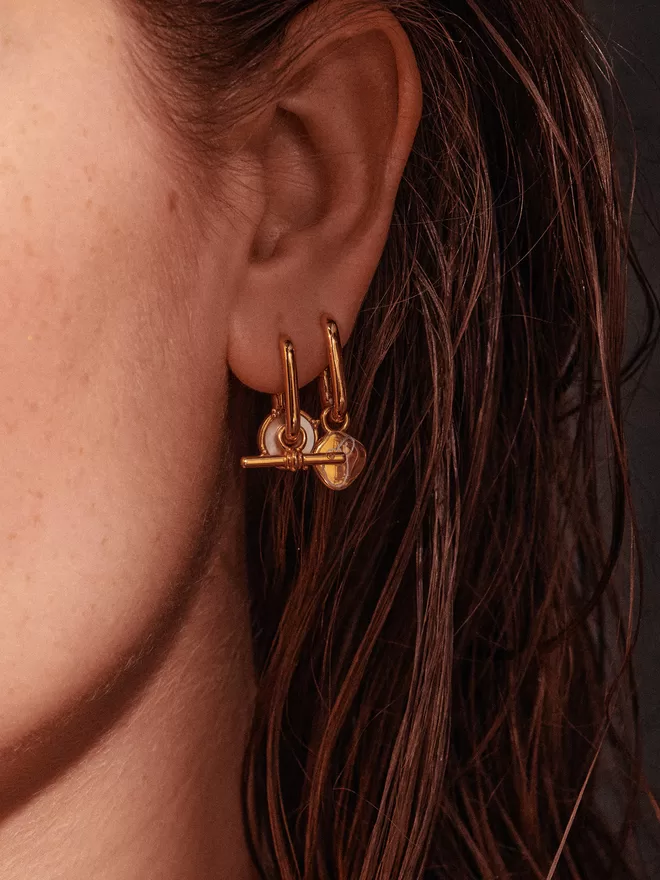 woman wearing gold earrings with charms