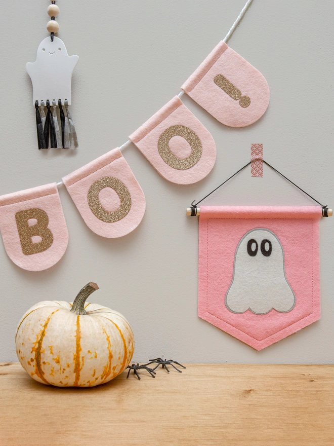 cute halloween ghost on a soft pastel pink banner. The banner is presented next to Blush pink scalloped bunting with champagne gold glitter text that says "BOO!'