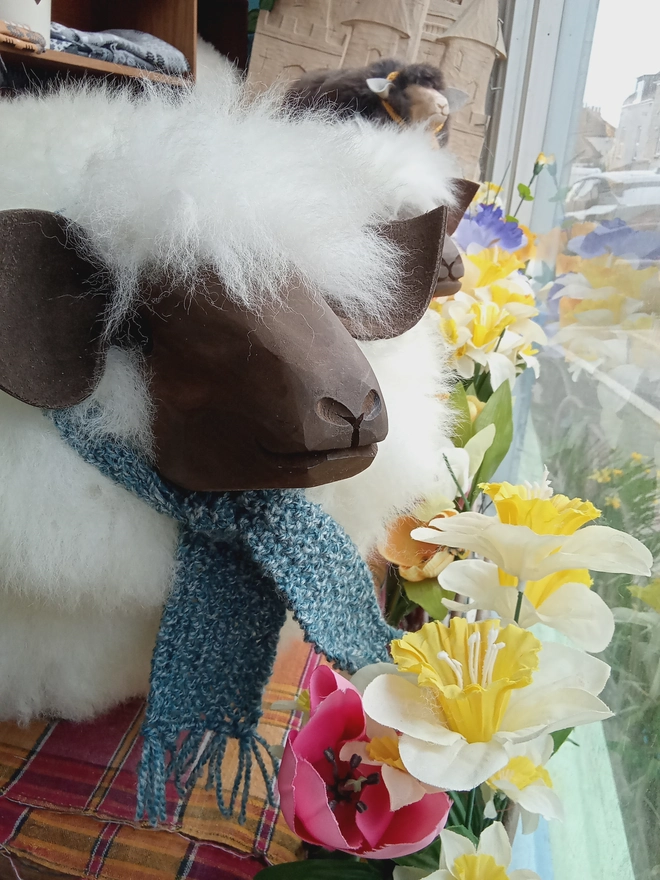 Sheep footstool with a blue scarf