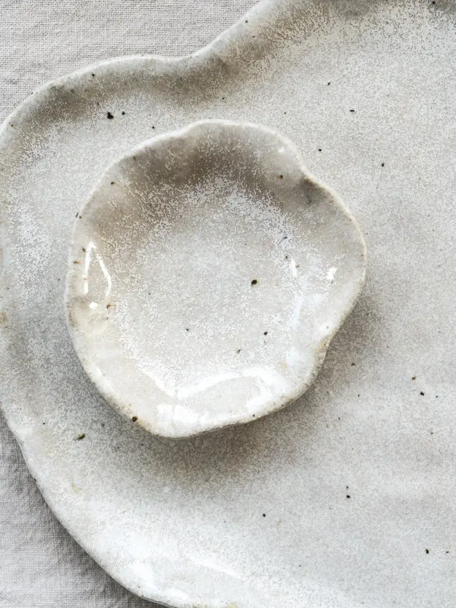 Lily Pad Jewellery Dish In Sea Salt Glaze, dishes stacked on top of each other, on a table cloth. 