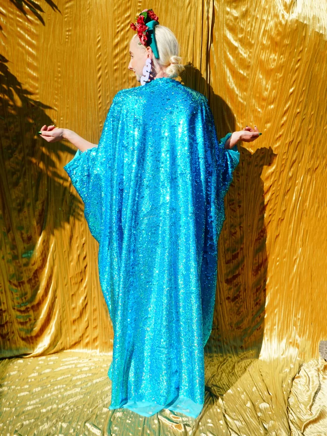 Turquoise Holographic Sequin V-neck Kaftan Gown seen from the back.