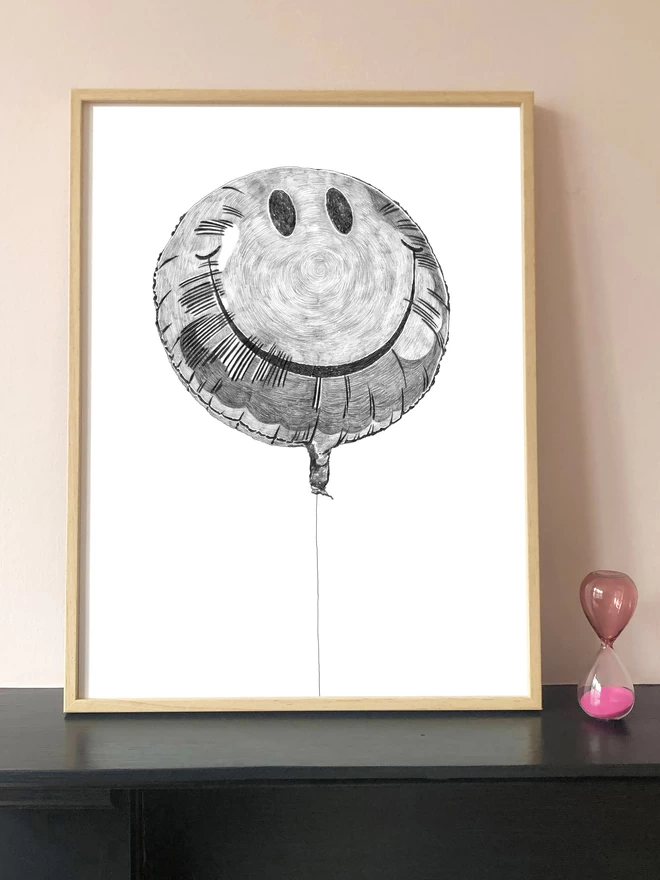 Art print of a hand drawn illustration of a smiley balloon displayed in a frame