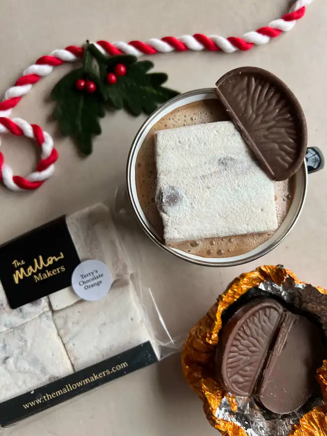The-Mallow-Makers-close-up-of-hot-chocolate-with-packet-of-marshmallows-and-chocolate-orange-pieces