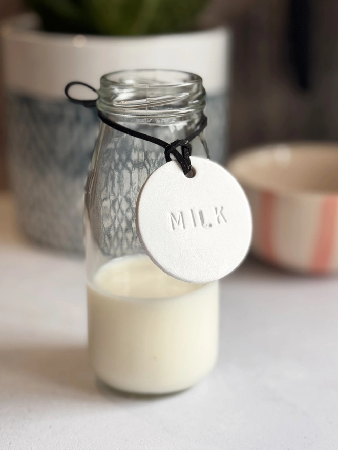 Minimalist white leather pantry tags with hand-stamped labels for kitchen storage. Rustic and stylish labels with black cord, ideal for home organisation and pantry décor.