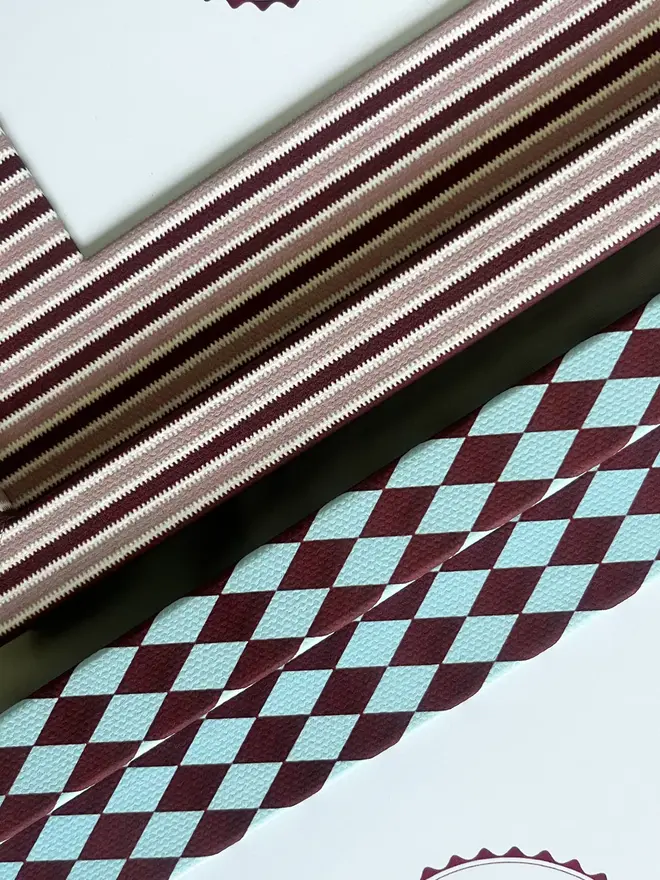 Burgundy & Blue Harlequin Frame, a patterned colourful frame sitting on a plain white surface. It is joined by another frame. 