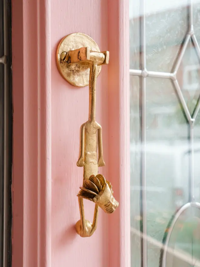 lion door knocker on pink door