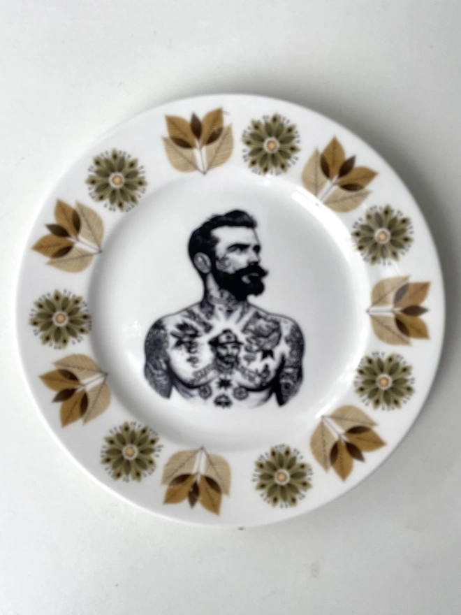a vintage plate with ornate border, within the centre i have printed the vintage style image of a victorian tattooed sailor man