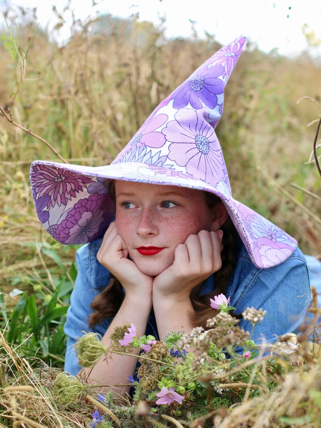 Woman in field wearing purple witch hat handmade in England