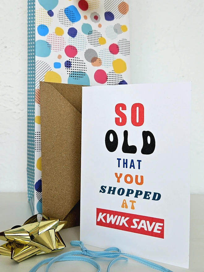 A photograph of the front of a humorous A6 greeting card illustrated using brightly coloured text and the retro shop logo. The text says so old you shopped at Kwik Save.