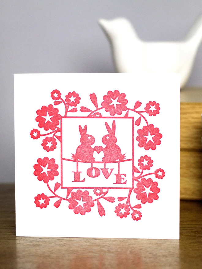 Letterpress lovebunnies design printed in red ink onto soft white square card