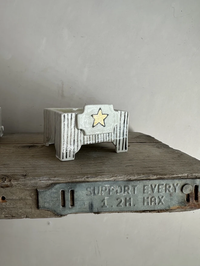 square star candle holder on shelf
