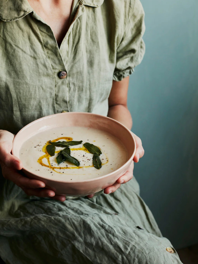 'sunrise' handcrafted stoneware bowls. a medium pink bowl containing soup.