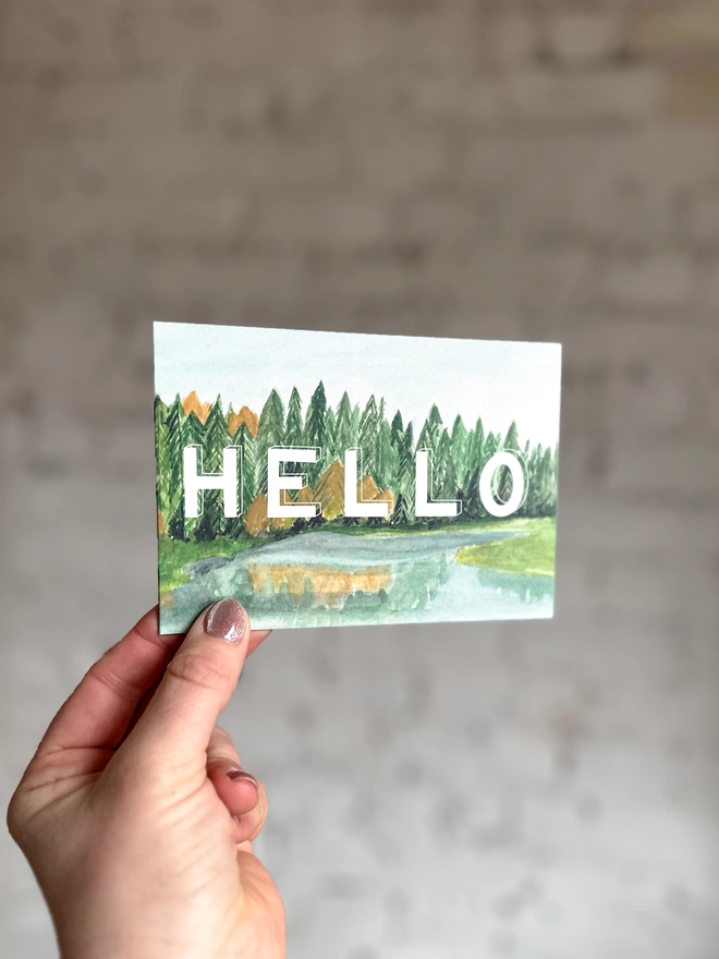 a greetings card featuring an illustration of some of the Taiga landscape with the text “hello”