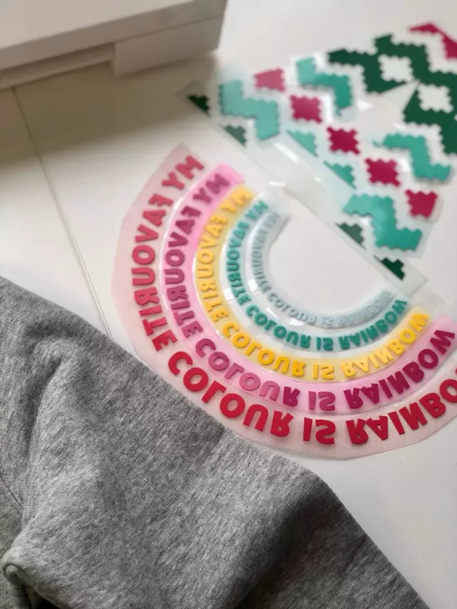 a 'Rainbow' Sweatshirt by The Faraway Gang with a rainbow on it.